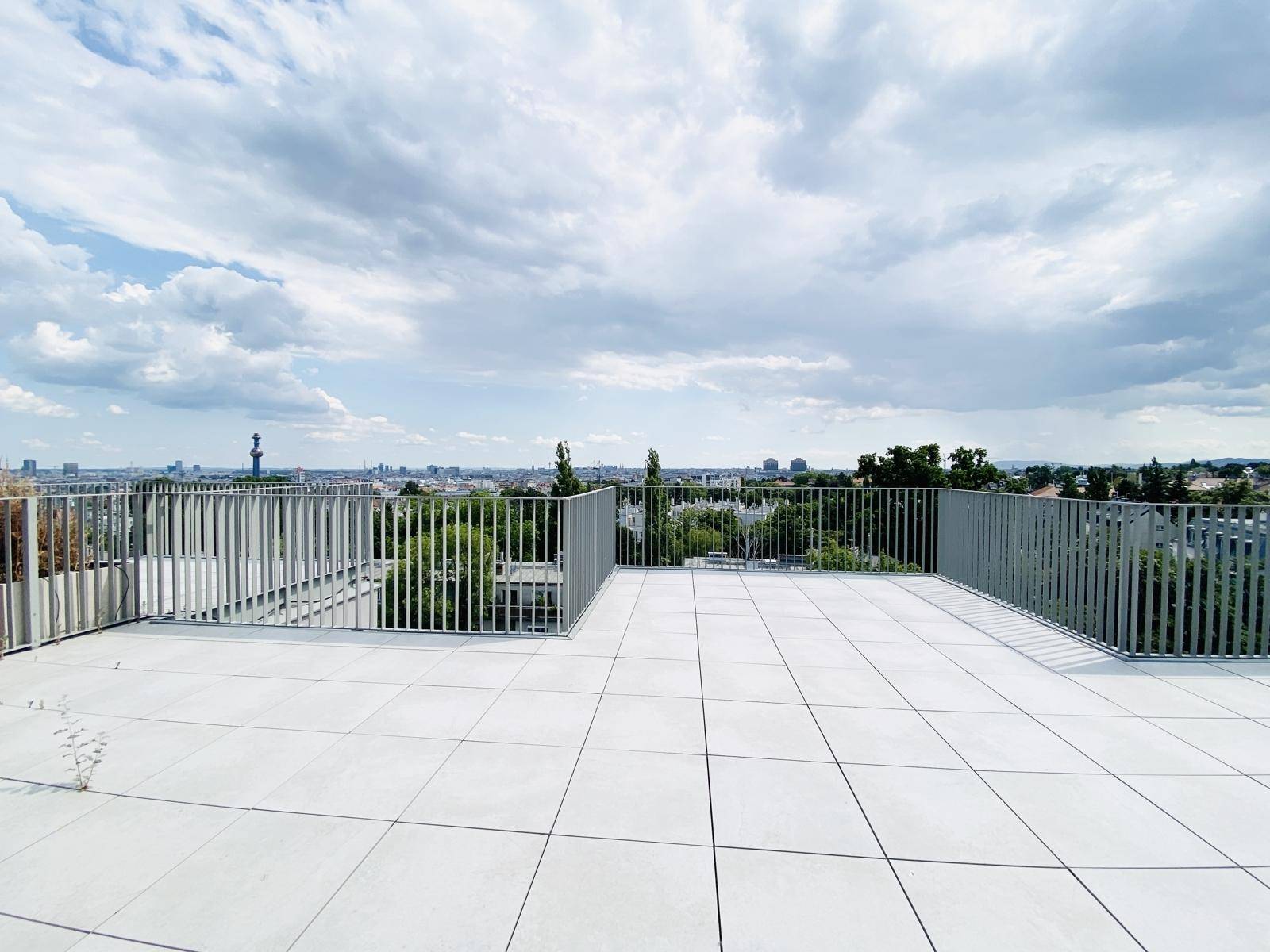 Große Dachterrasse mit weitem Stadtblick und modernem Geländer, ideal für Entspannung im Freien.