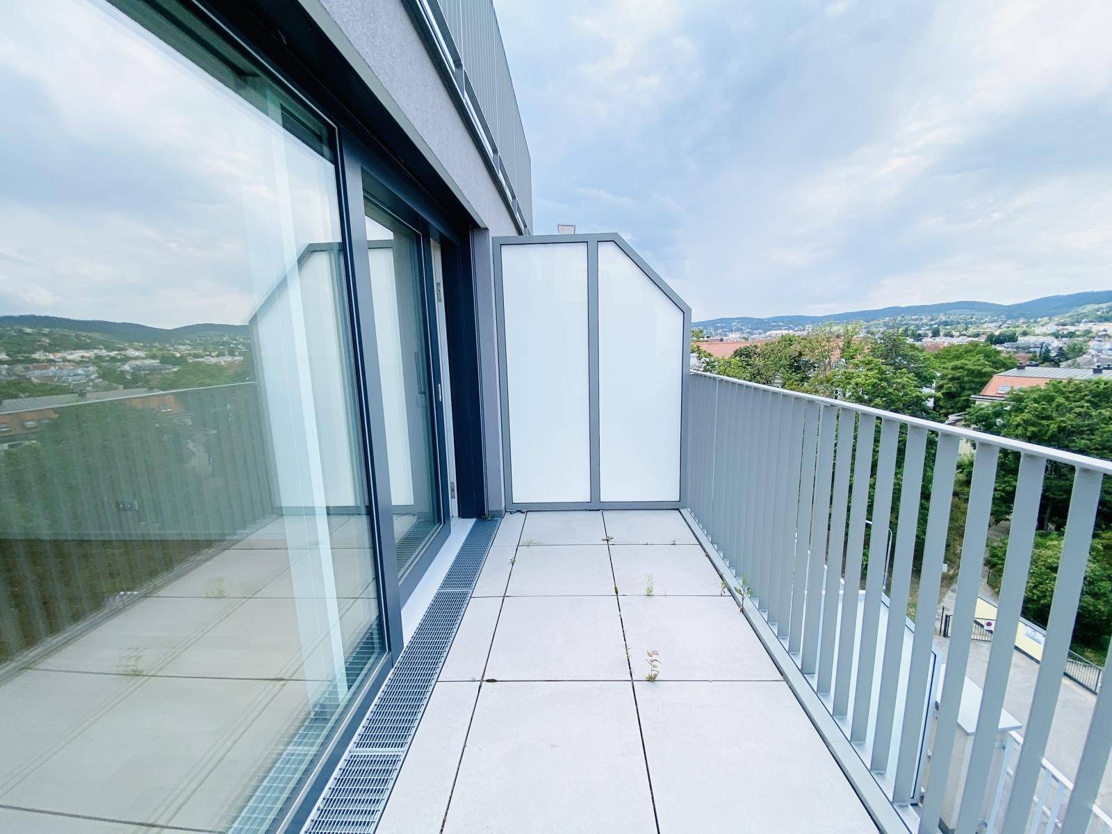 Schmaler Balkon mit Fliesenboden und moderner Verglasung, bietet einen schönen Ausblick.