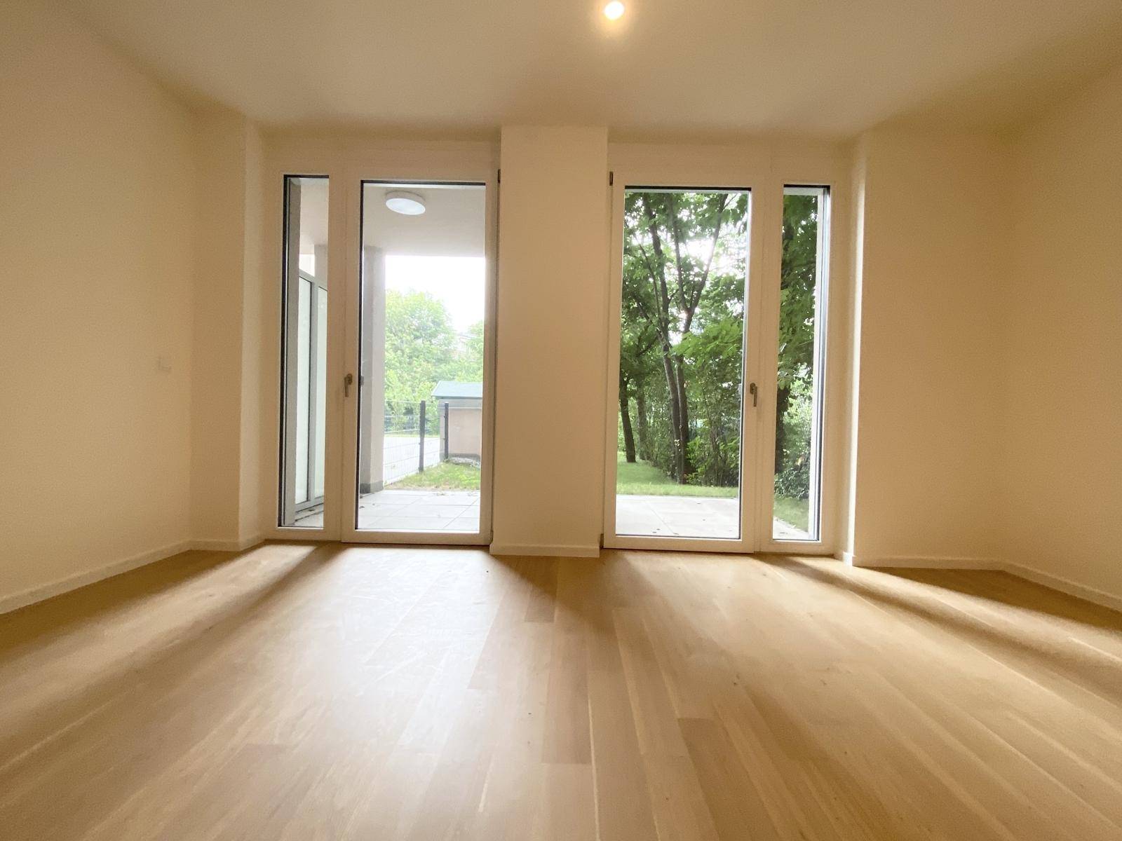 Große Glastüren bieten Zugang zu einer Terrasse und einen Blick ins Grüne.