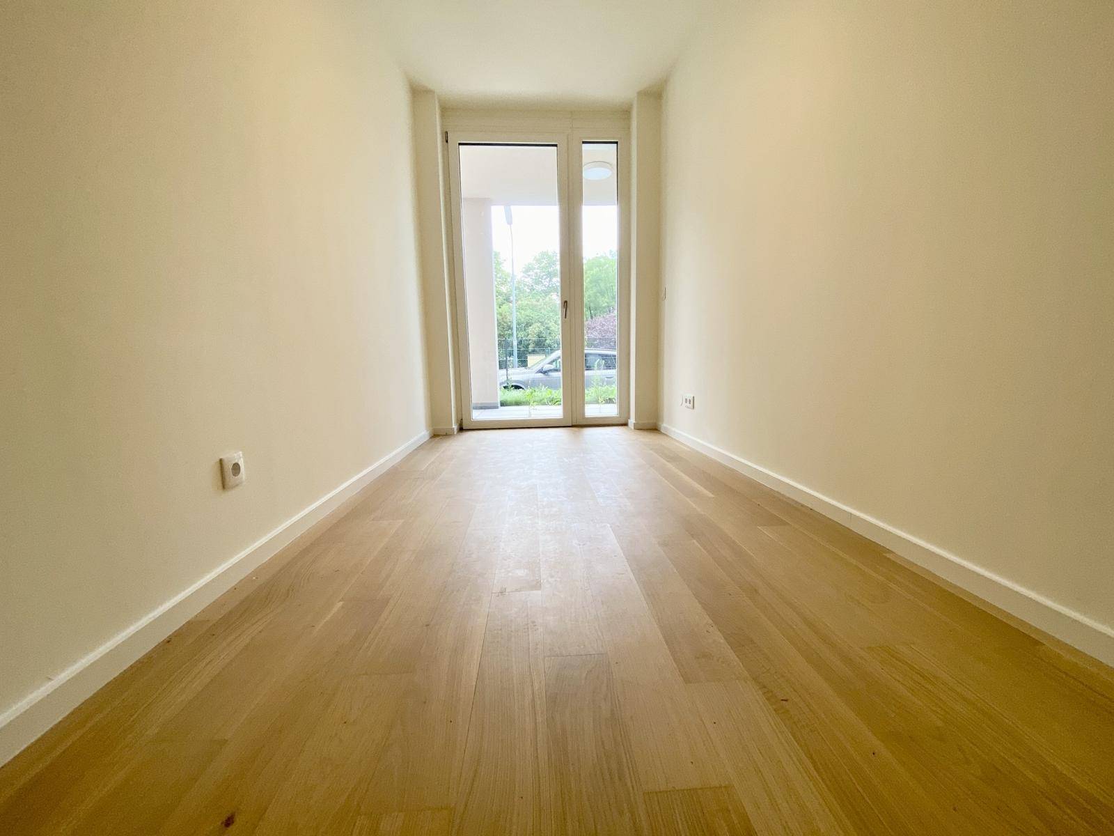 Modernes Schlafzimmer mit Parkettboden und bodentiefen Fenstern für viel Helligkeit.