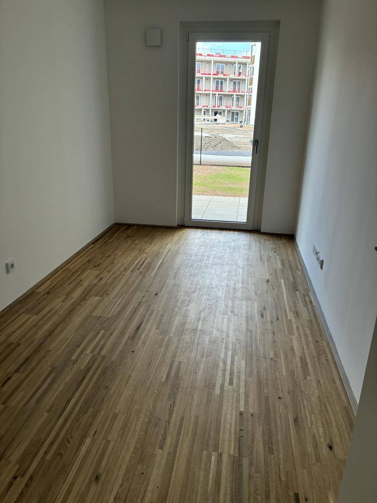 Heller Parkettboden in einem der Schlafzimmer mit direktem Zugang ins Freie.