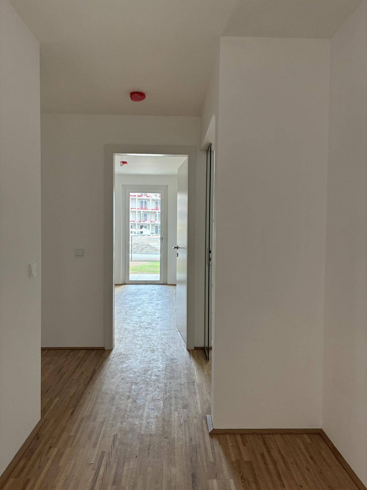 Heller Flur mit Parkettboden und Blick auf den Eingangsbereich.