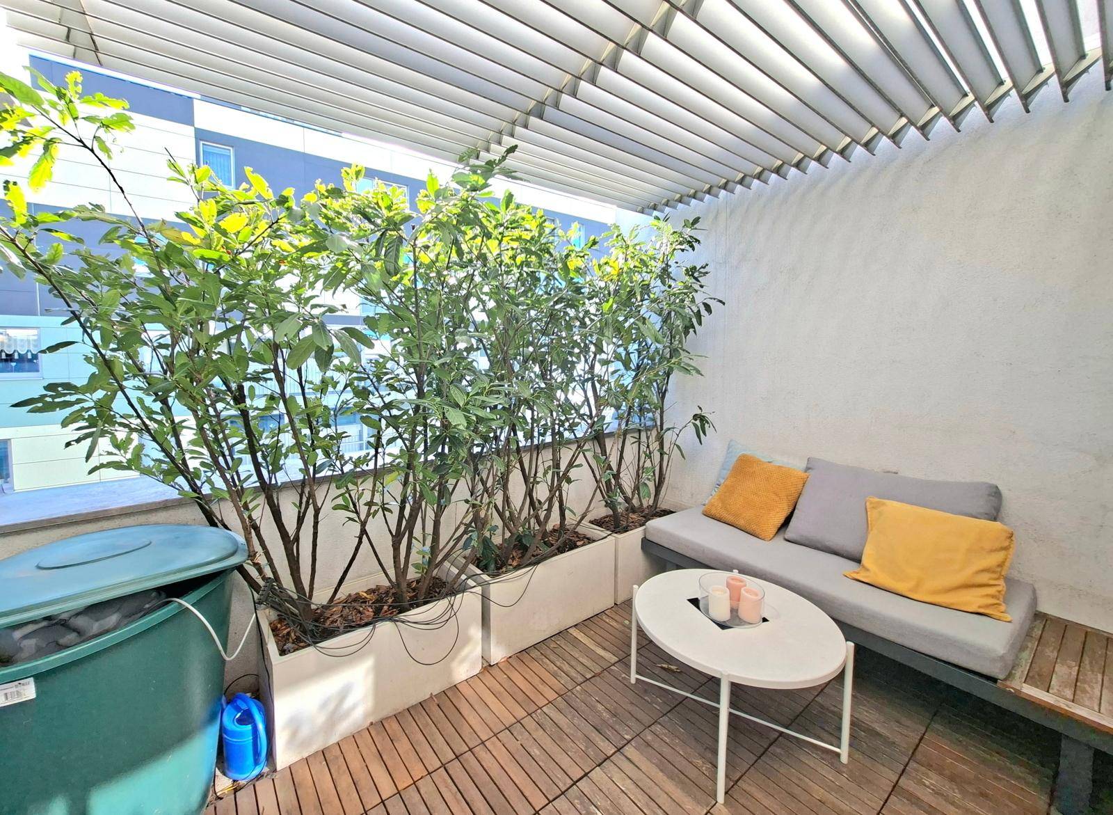 Gemütlicher Balkon mit Sitzgelegenheiten und Pflanzen, ideal für entspannte Stunden im Freien.