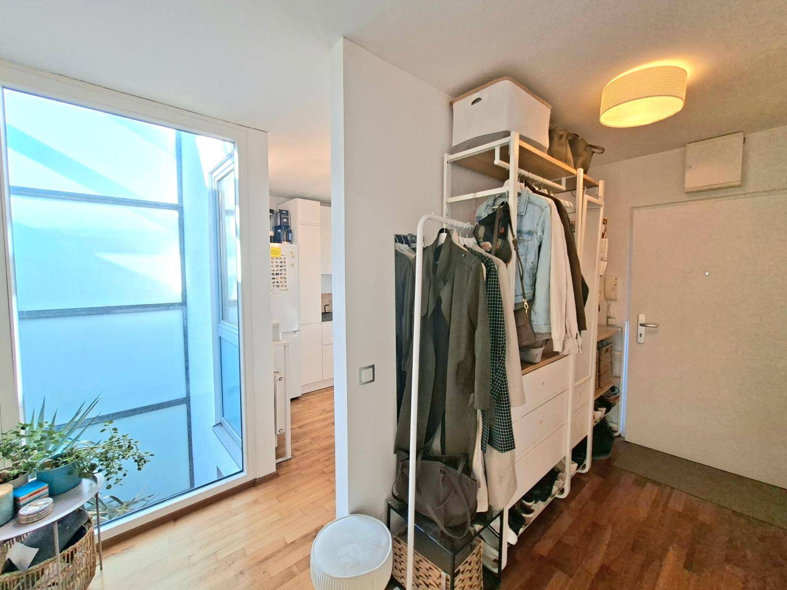 Eingangsbereich mit Garderobe und Holzboden, der zu den Wohnbereichen und der Küche führt.