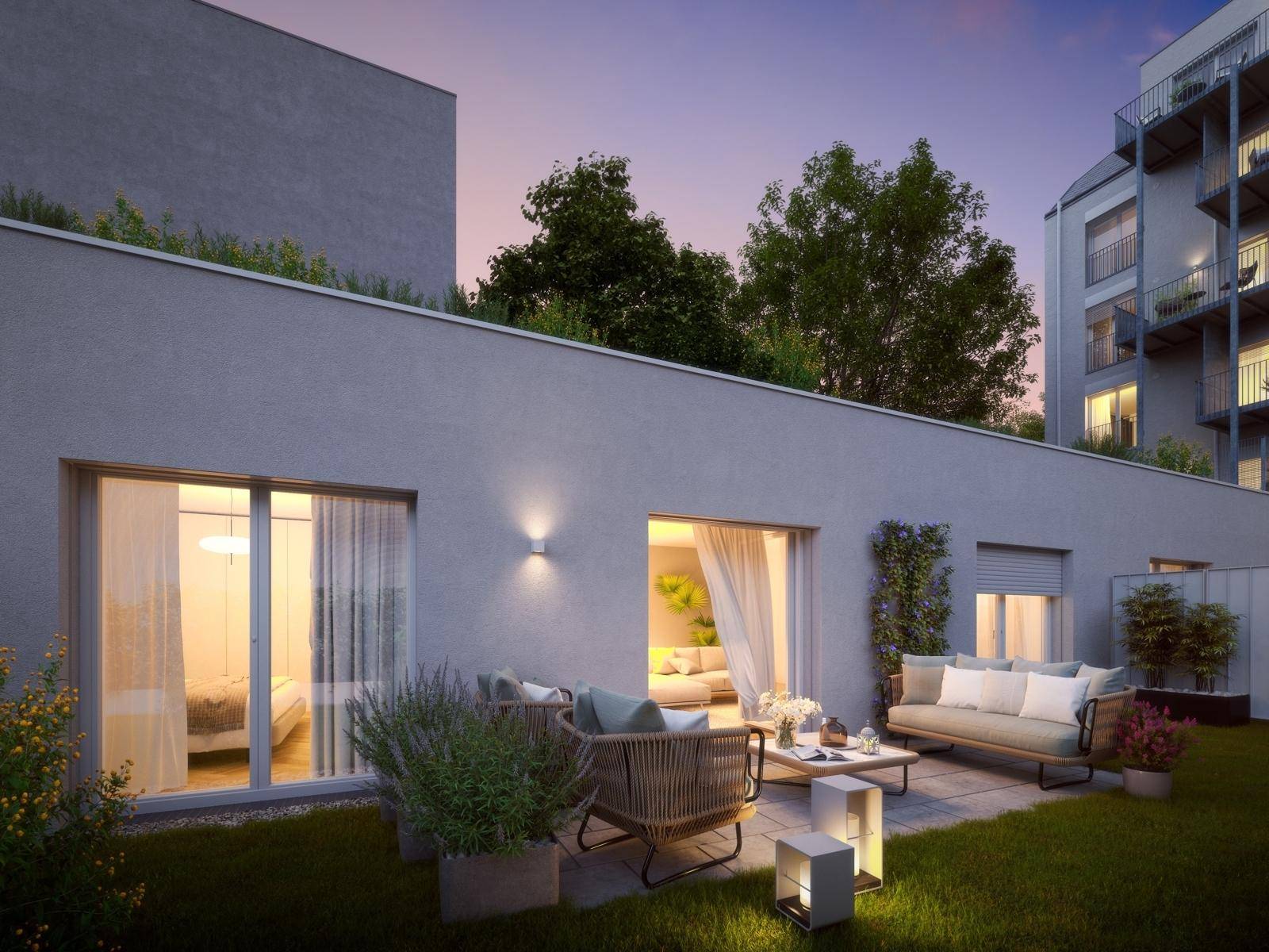 Gemütliche Terrasse mit modernen Sitzgelegenheiten und Zugang zu einem kleinen privaten Gartenbereich am Abend.