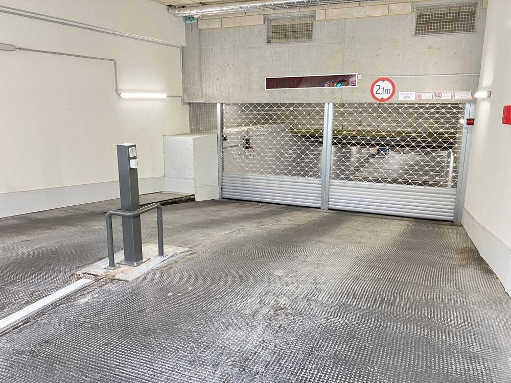 Einfahrt zur Tiefgarage mit Rolltor und Höhenbegrenzung von 2,1 Metern.