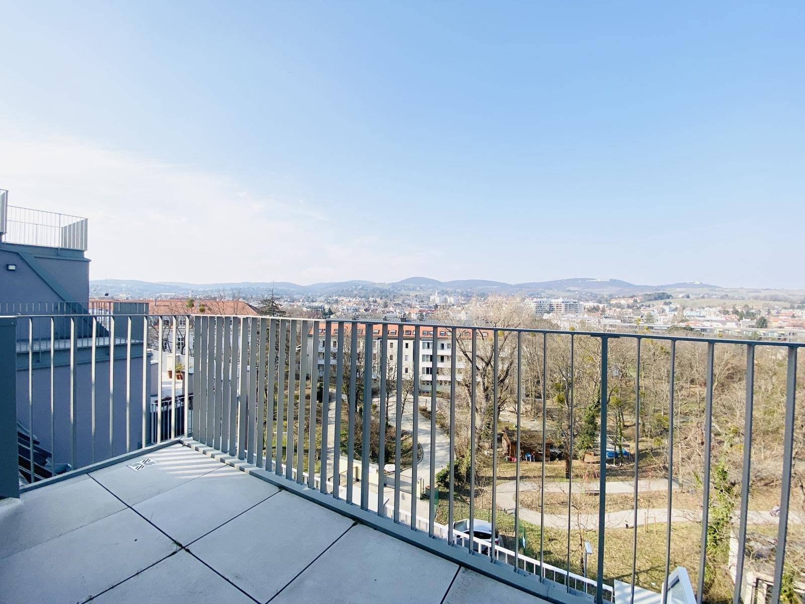 Sonniger Balkon mit weitem Blick über die Stadt und die umliegende Landschaft.
