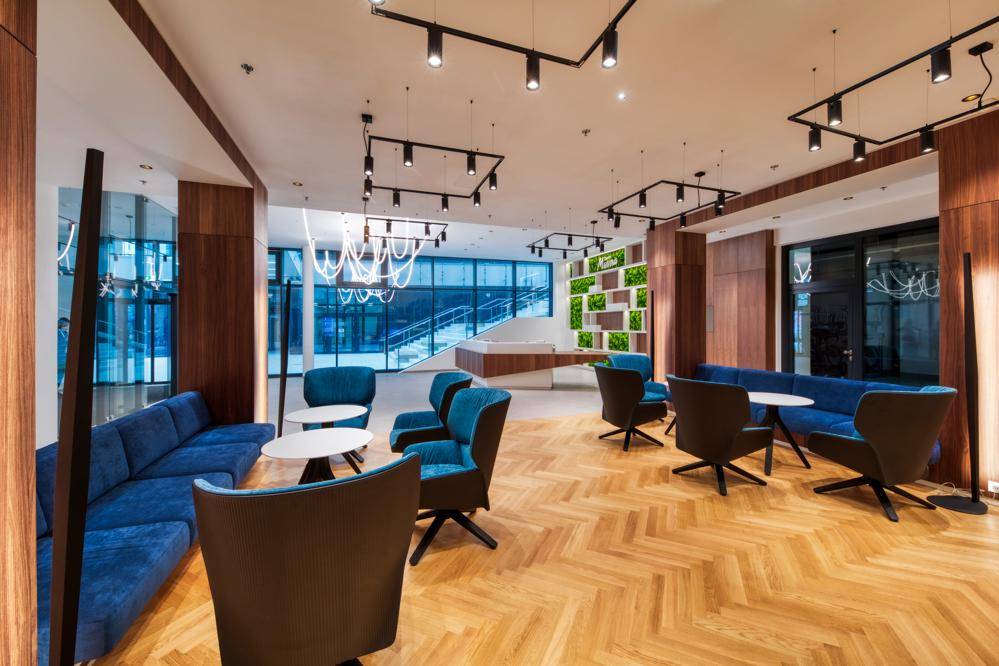 Stilvolle Gemeinschaftslounge mit modernen Sitzgelegenheiten und Holzparkettboden.