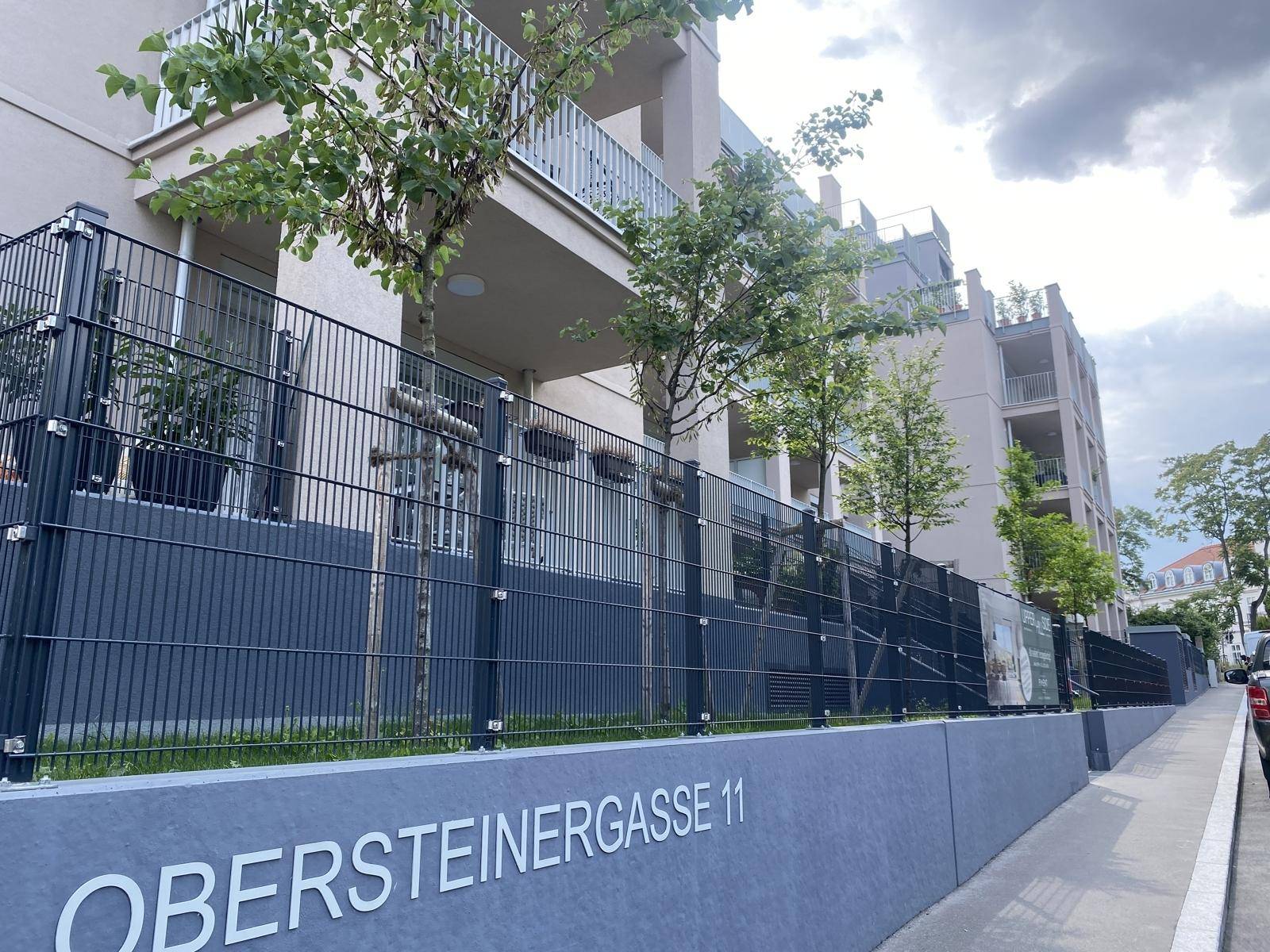 Ansicht eines modernen Mehrfamilienhauses mit mehreren Balkonen und zeitgenössischer Architektur.