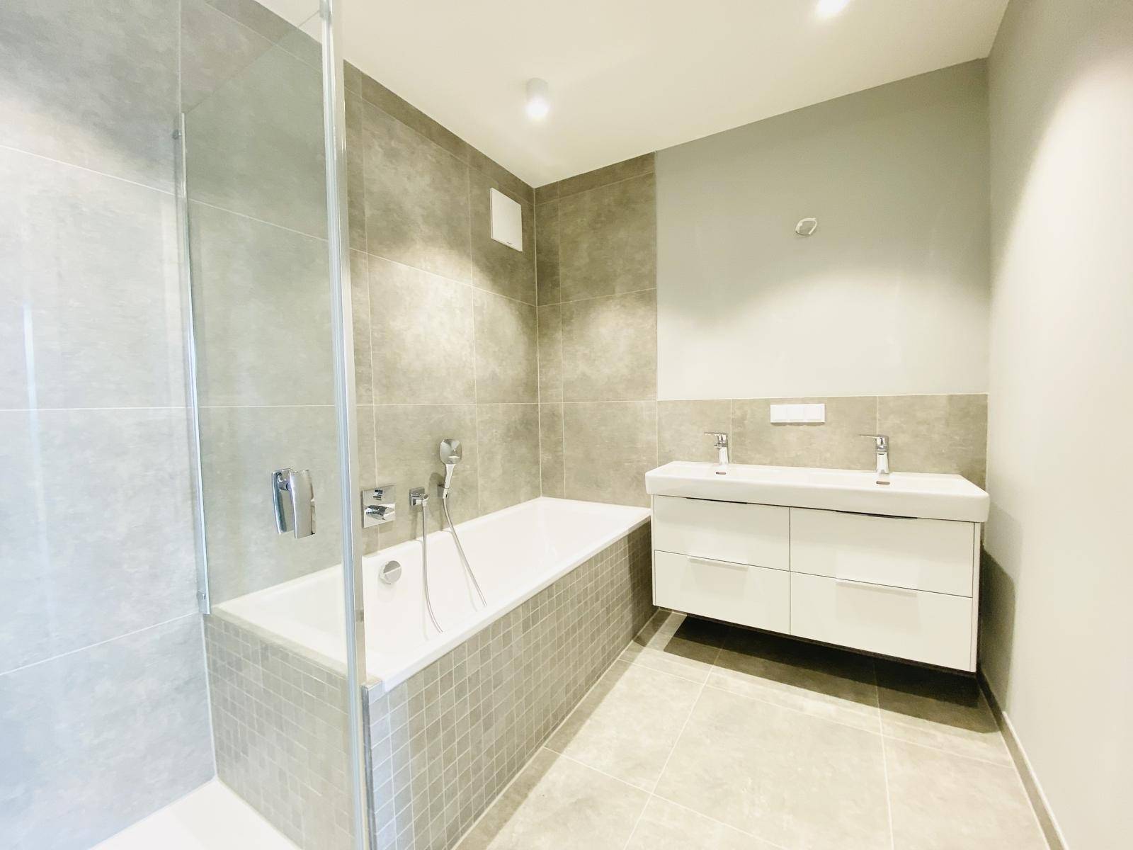 Modernes Badezimmer mit Badewanne, Dusche und Doppelwaschbecken.