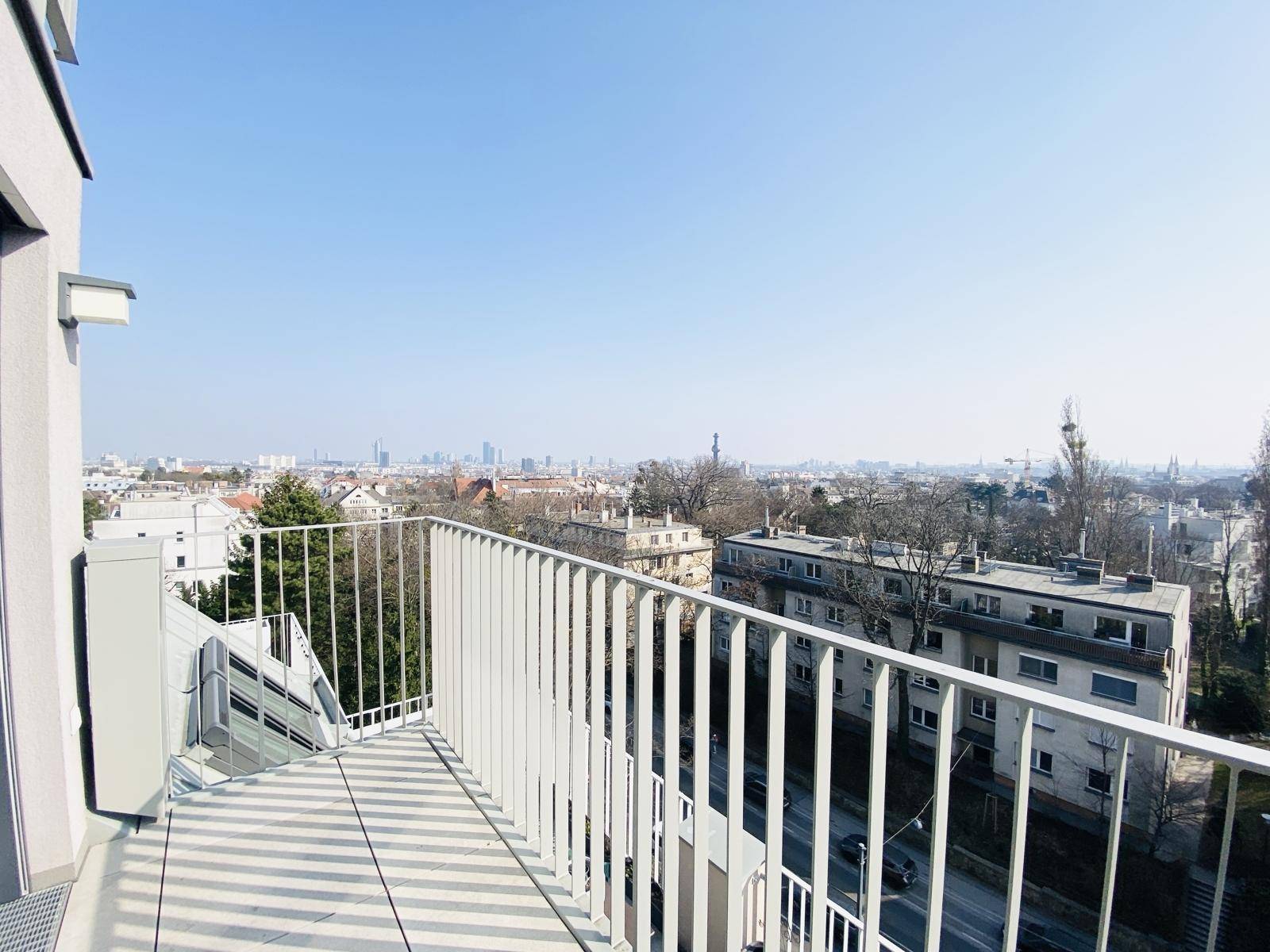Moderner Balkon mit Metallgeländer und Panoramablick auf die Stadt und die Umgebung.