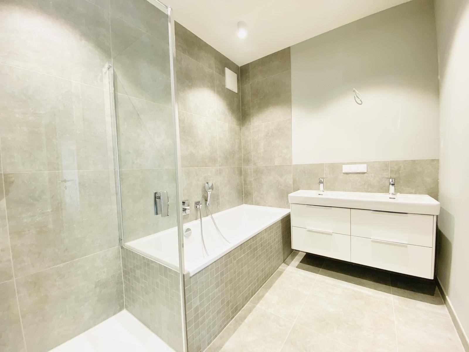 Modernes Badezimmer mit Badewanne, Dusche und Doppelwaschbecken.