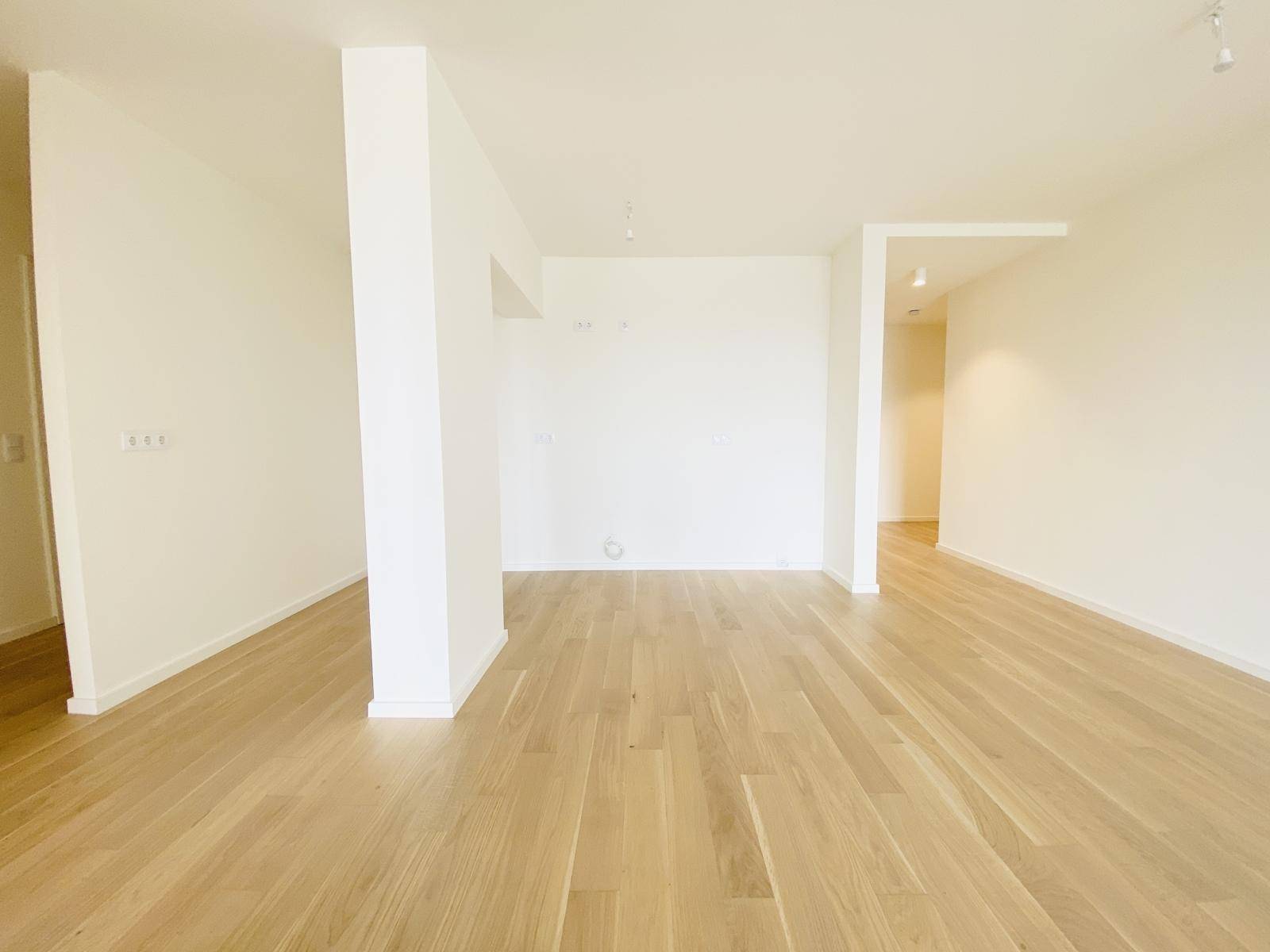 Offener Wohnbereich mit hellem Holzboden und viel Platz für individuelle Gestaltung.