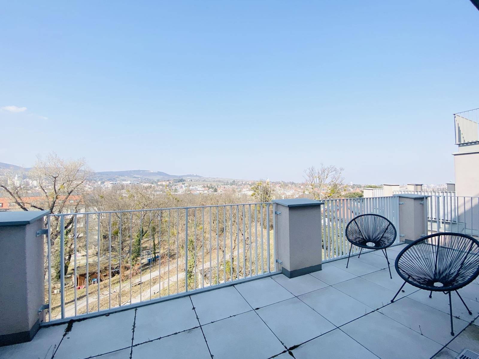 Geräumige Dachterrasse mit Weitblick über die Stadt und die umliegende grüne Landschaft.