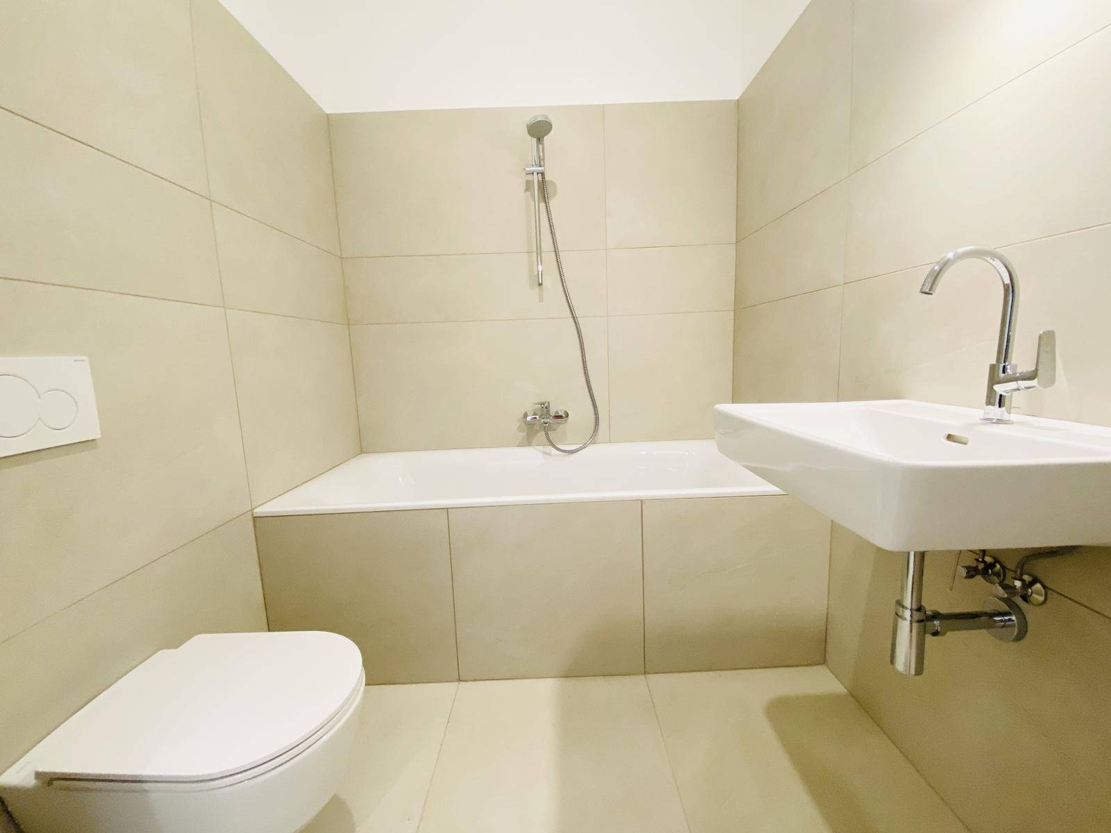 Modernes Badezimmer mit Badewanne, wandhängendem WC und Waschbecken.