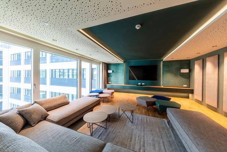 Gemütlicher Medienraum mit großem Bildschirm, bequemen Sofas und Holzboden.