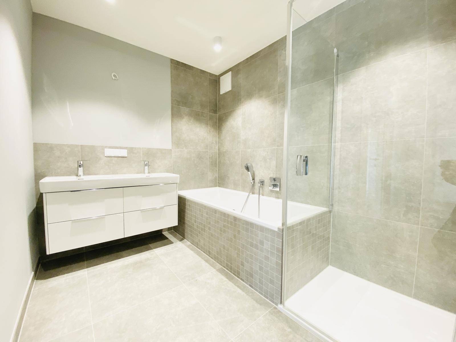 Modernes Badezimmer mit Doppelwaschbecken, Badewanne und separater Dusche.