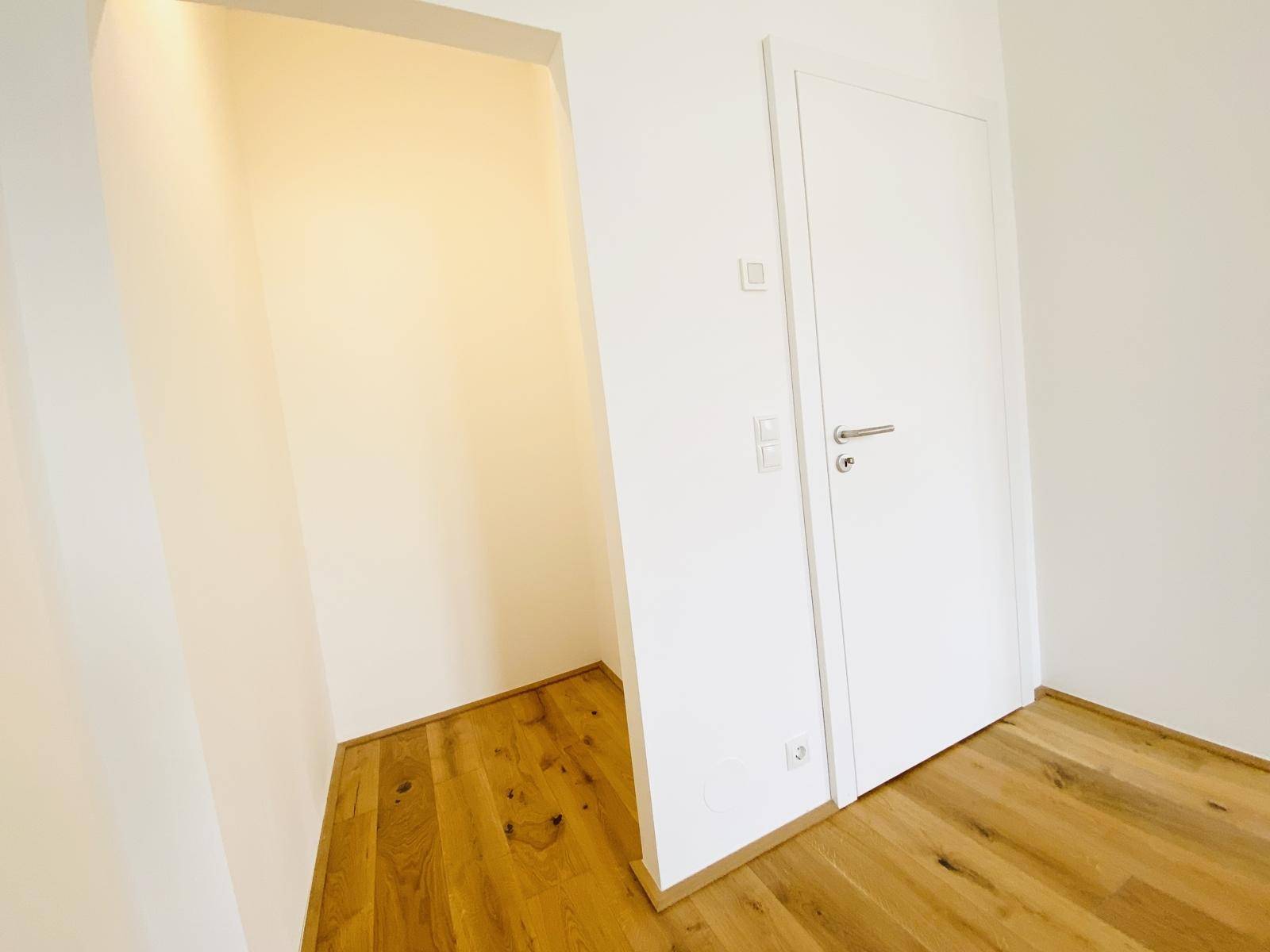Heller Flurbereich mit Holzboden und einer Nische, ideal für Einbauschränke.