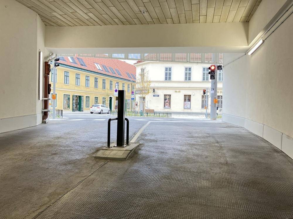 Blick aus der Tiefgarageneinfahrt auf die Straße und gegenüberliegende Gebäude.