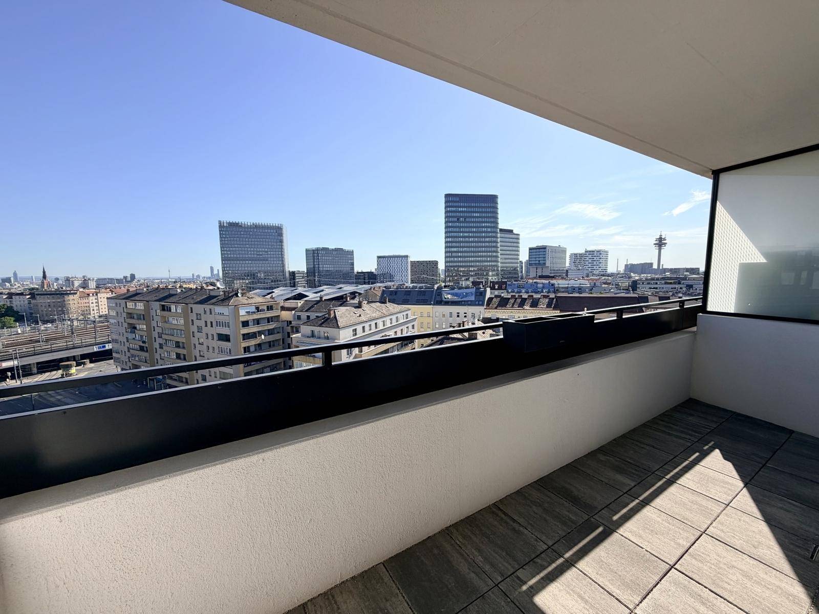 Geräumiger Balkon mit Fliesenboden und weitem Blick über die Stadt.