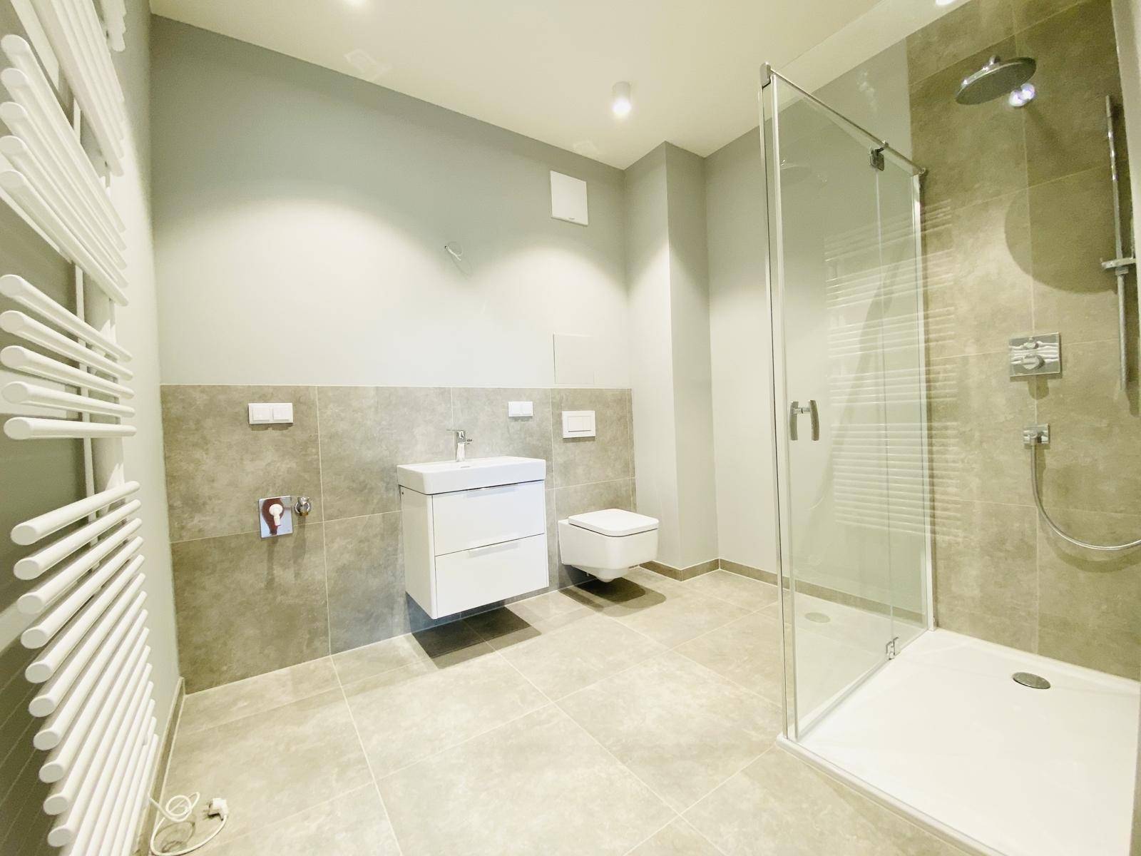 Modernes Badezimmer mit begehbarer Dusche, Wand-WC und beheiztem Handtuchhalter.