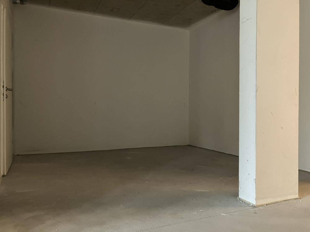 Kleinerer, unfertiger Raum mit Betonboden und weiß gestrichenen Wänden, bereit für den weiteren Ausbau.