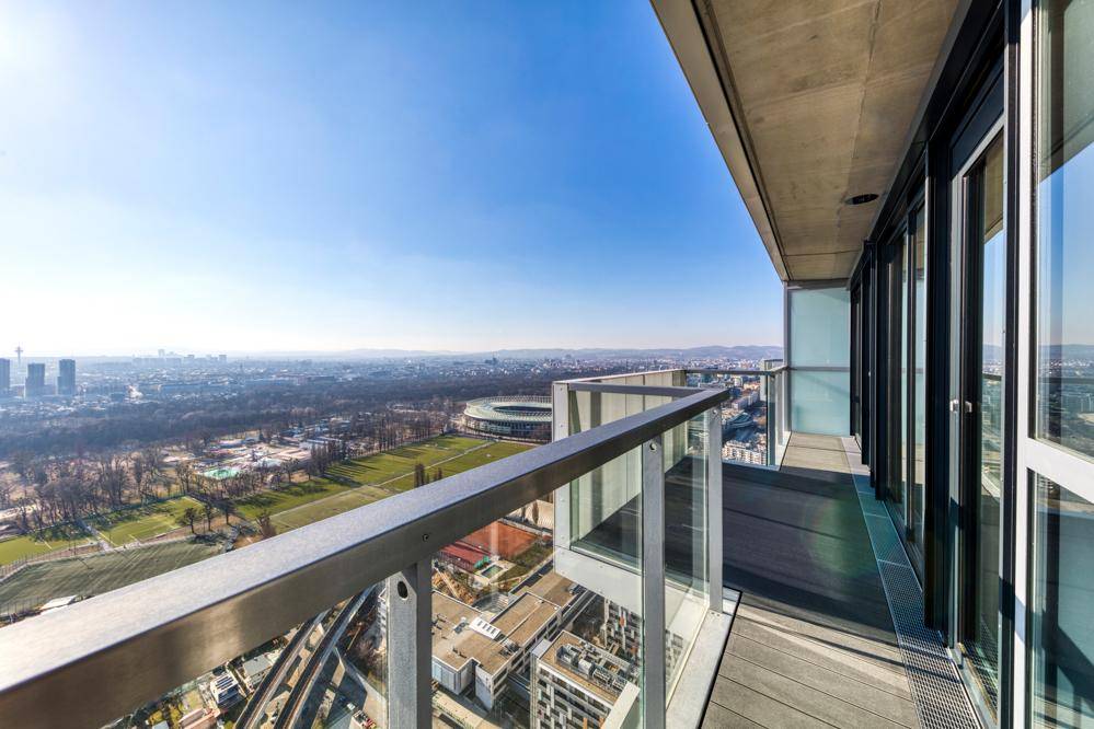Breiter Balkon mit Glasgeländer und Panoramablick auf die Stadt und den Prater.