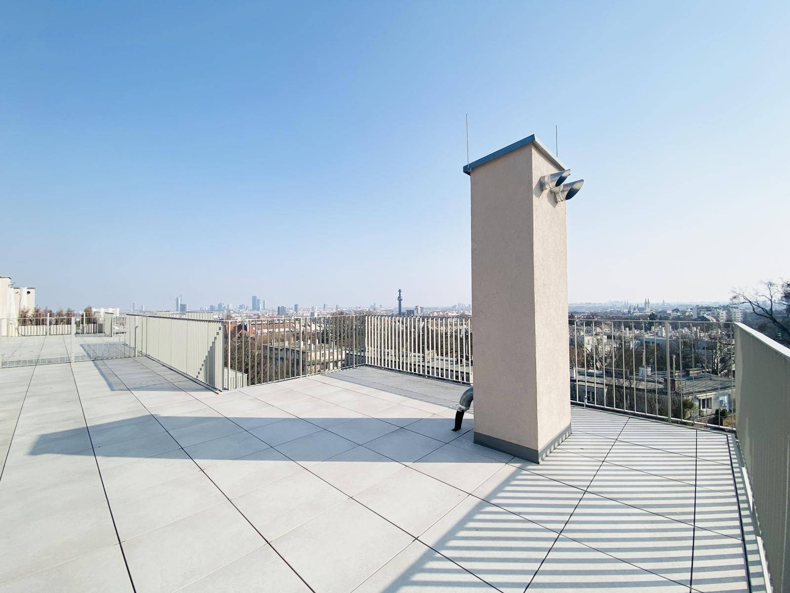 Sonniger Bereich der Dachterrasse mit Blick auf die Stadt und die umliegende Landschaft.