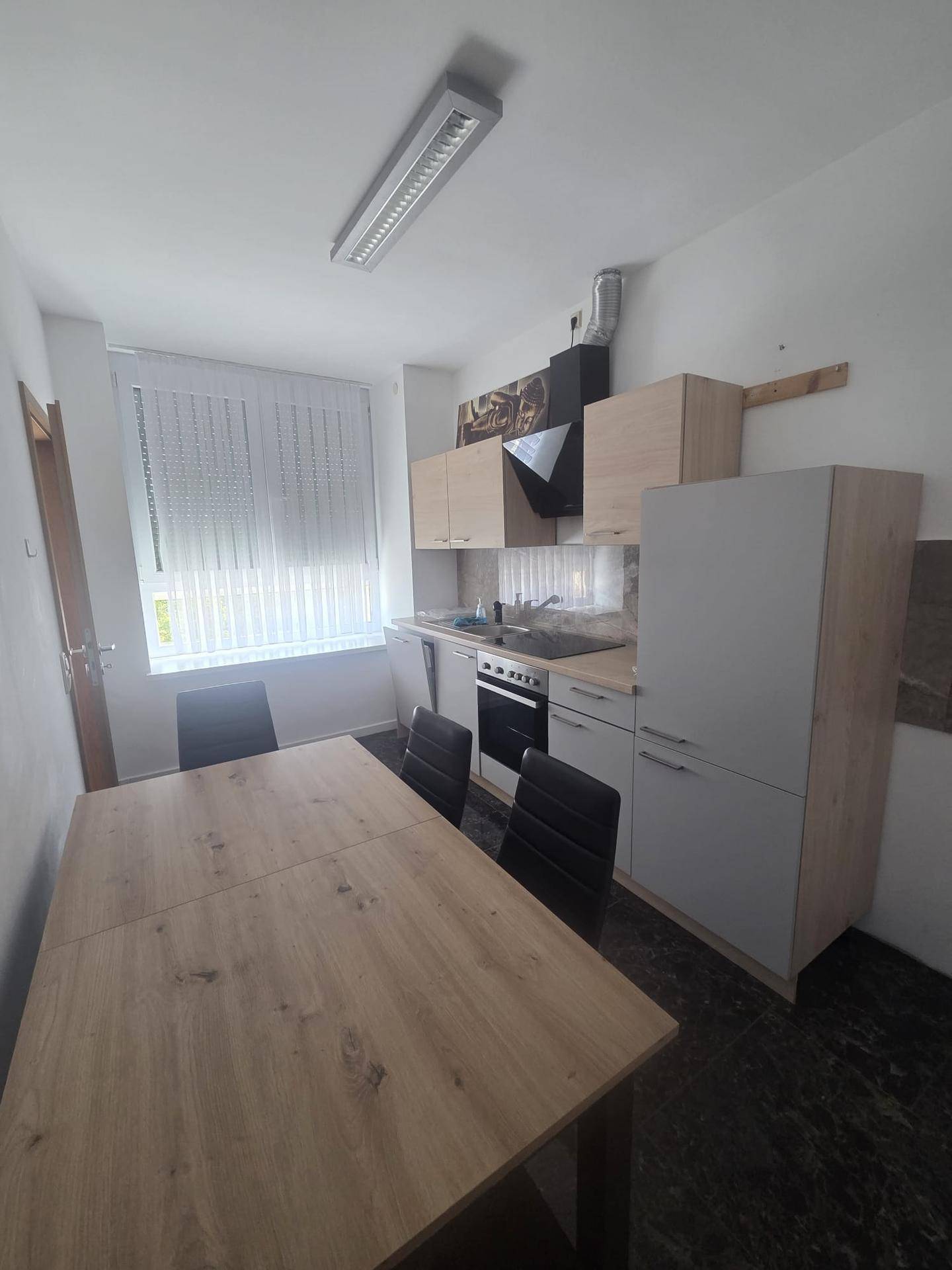 Funktionale Küche mit Essbereich, Fenster und modernen Einbauschränken.