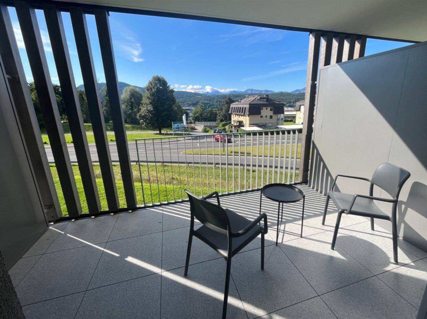 Geräumiger Balkon mit Sitzgelegenheiten und weitem Blick auf die Berge und Umgebung.