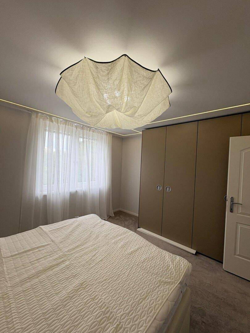 Gemütliches Schlafzimmer mit Einbauschrank, Teppichboden und indirekter Beleuchtung.
