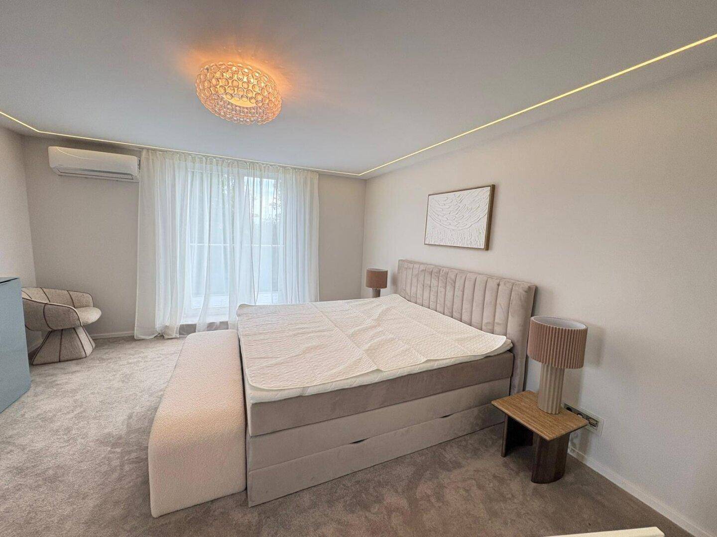 Modernes Schlafzimmer mit komfortablem Bett, Klimaanlage und weicher Beleuchtung.