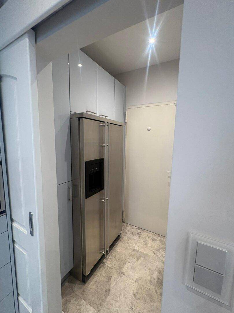 Flur mit Einbauschränken und integriertem Kühlschrank für zusätzlichen Stauraum.