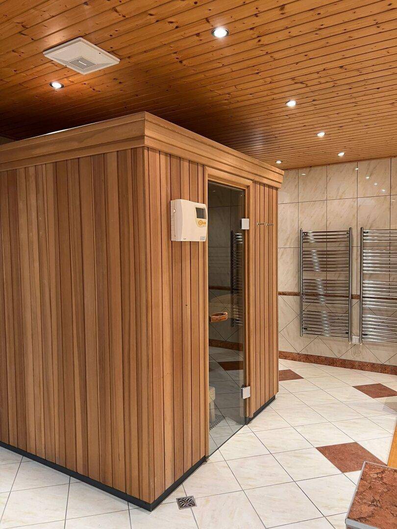 Entspannender Wellnessbereich mit moderner Sauna und gefliestem Boden.