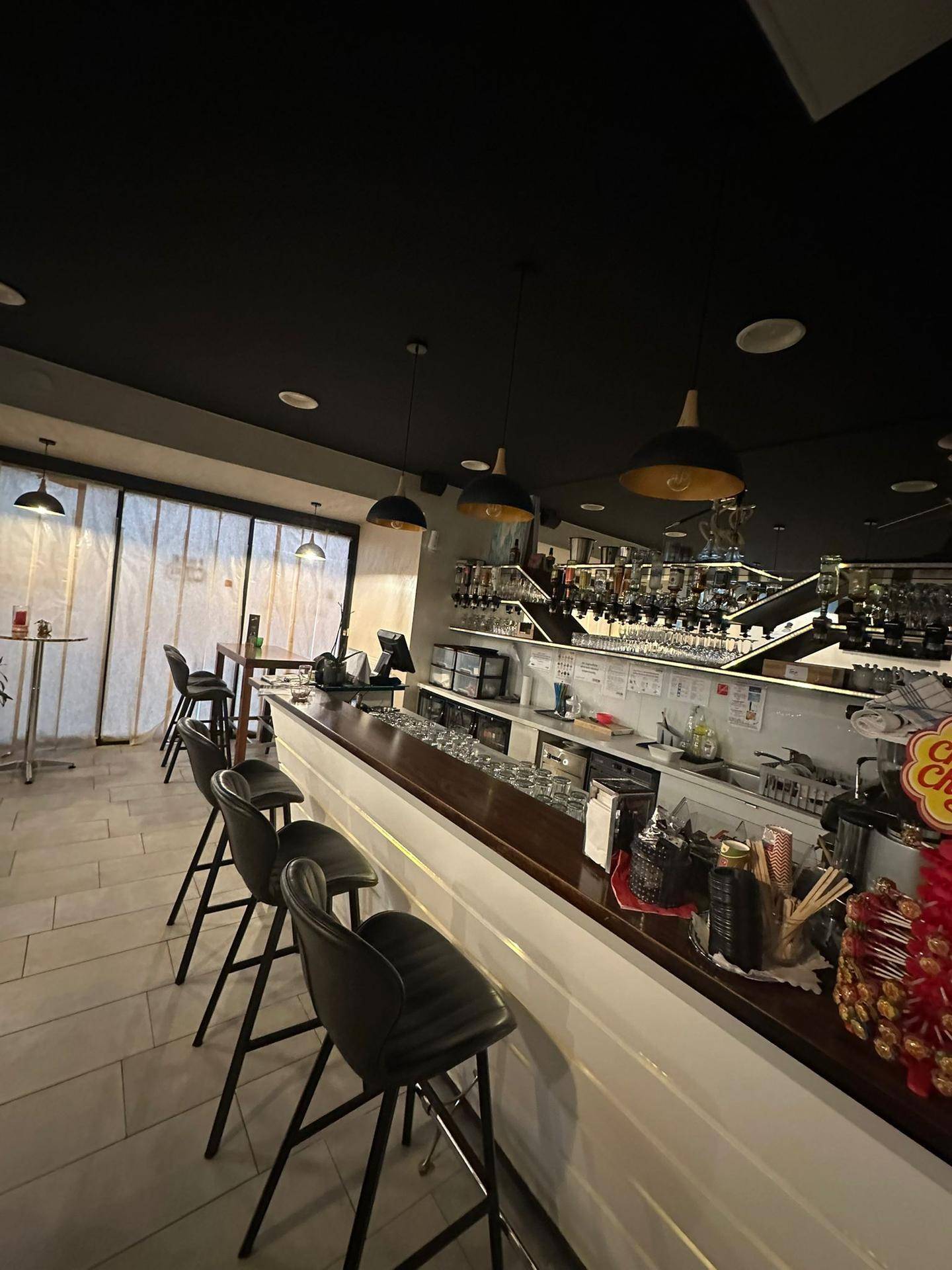 Nahaufnahme der Bar in der Lounge mit Barhockern, Gläsern und einer Theke.