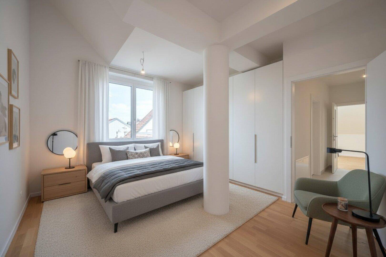 Helles Schlafzimmer mit Holzboden, großem Bett, Einbauschränken und Fenster.