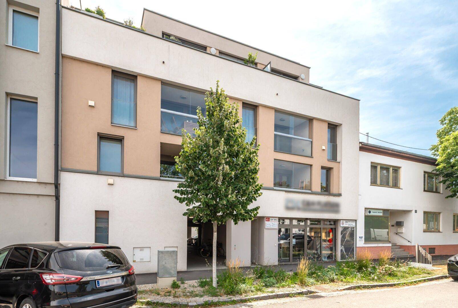 Moderne Wohnanlage mit Geschäften im Erdgeschoss und zeitgenössischer Architektur.