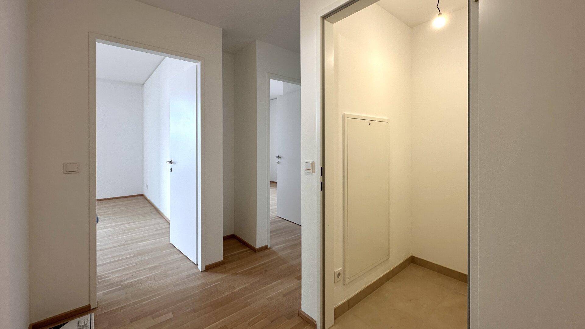 Heller Flur mit Zugang zu verschiedenen Zimmern und einem praktischen Abstellraum.