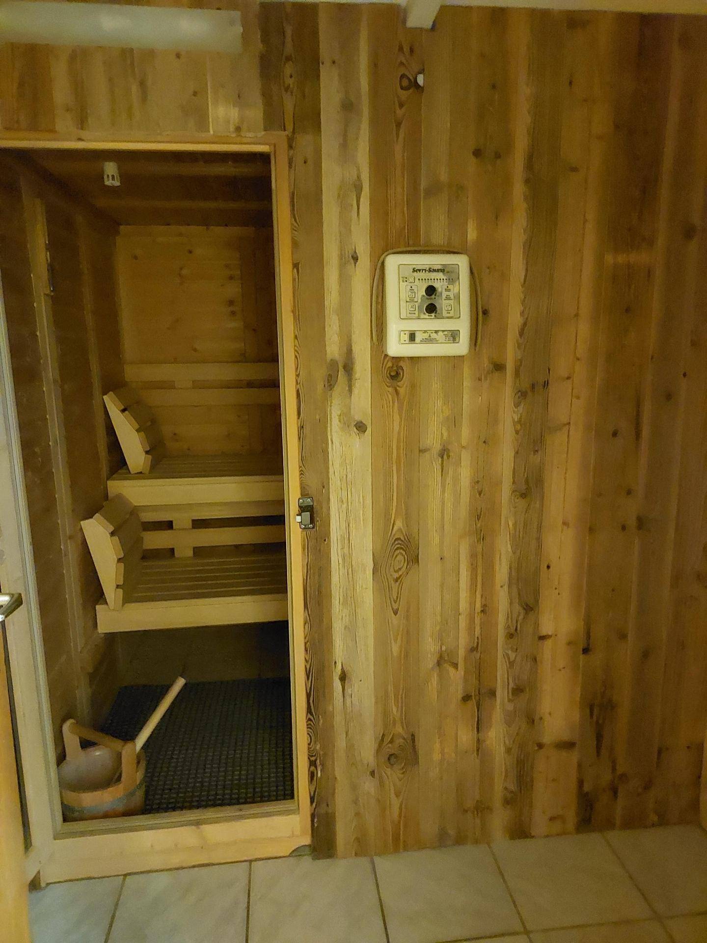 Private Sauna mit Holzbänken und Steuerungselementen für Entspannung.