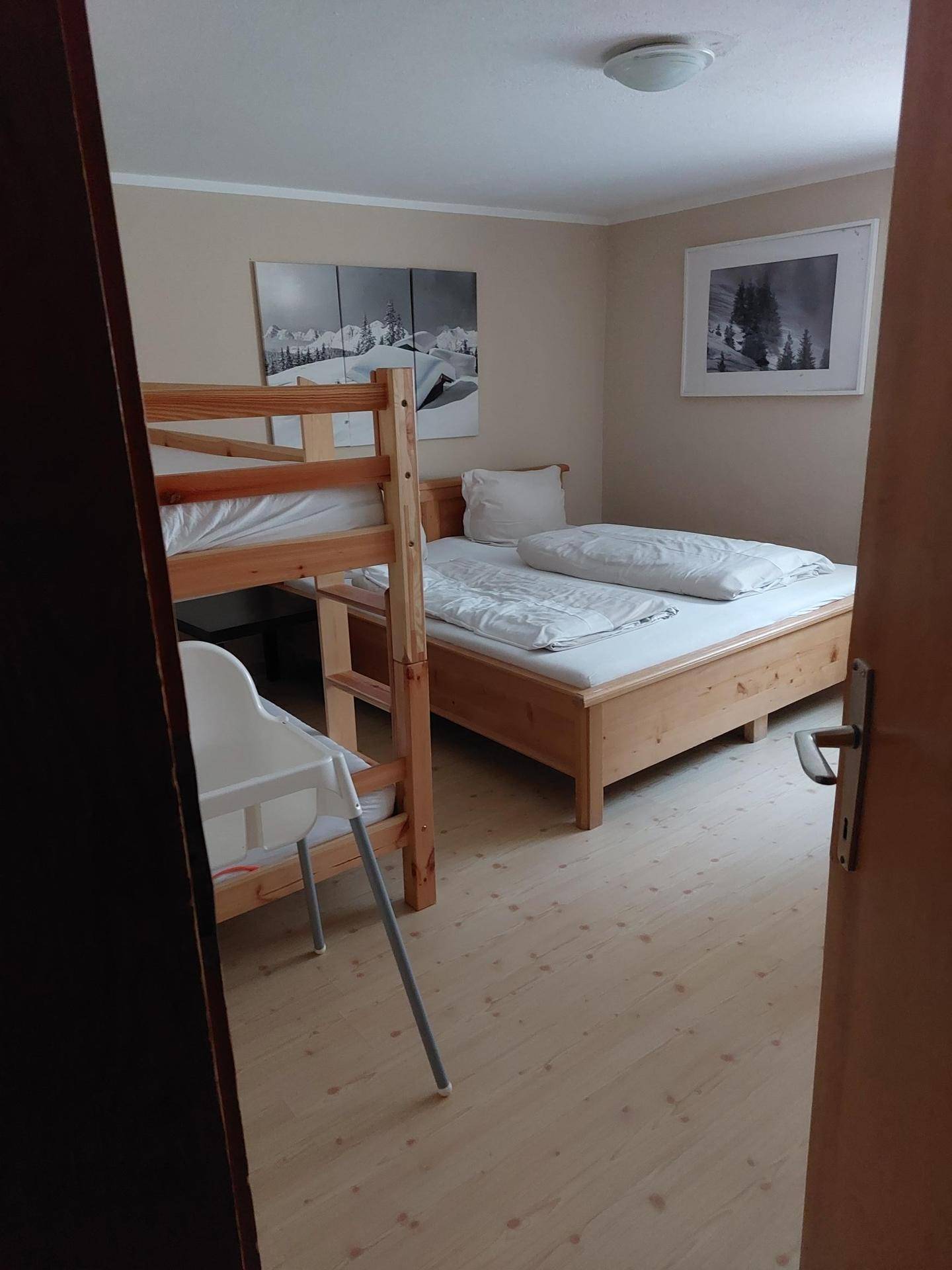 Kinderzimmer mit Etagenbett, Einzelbett und hellem Holzfußboden.
