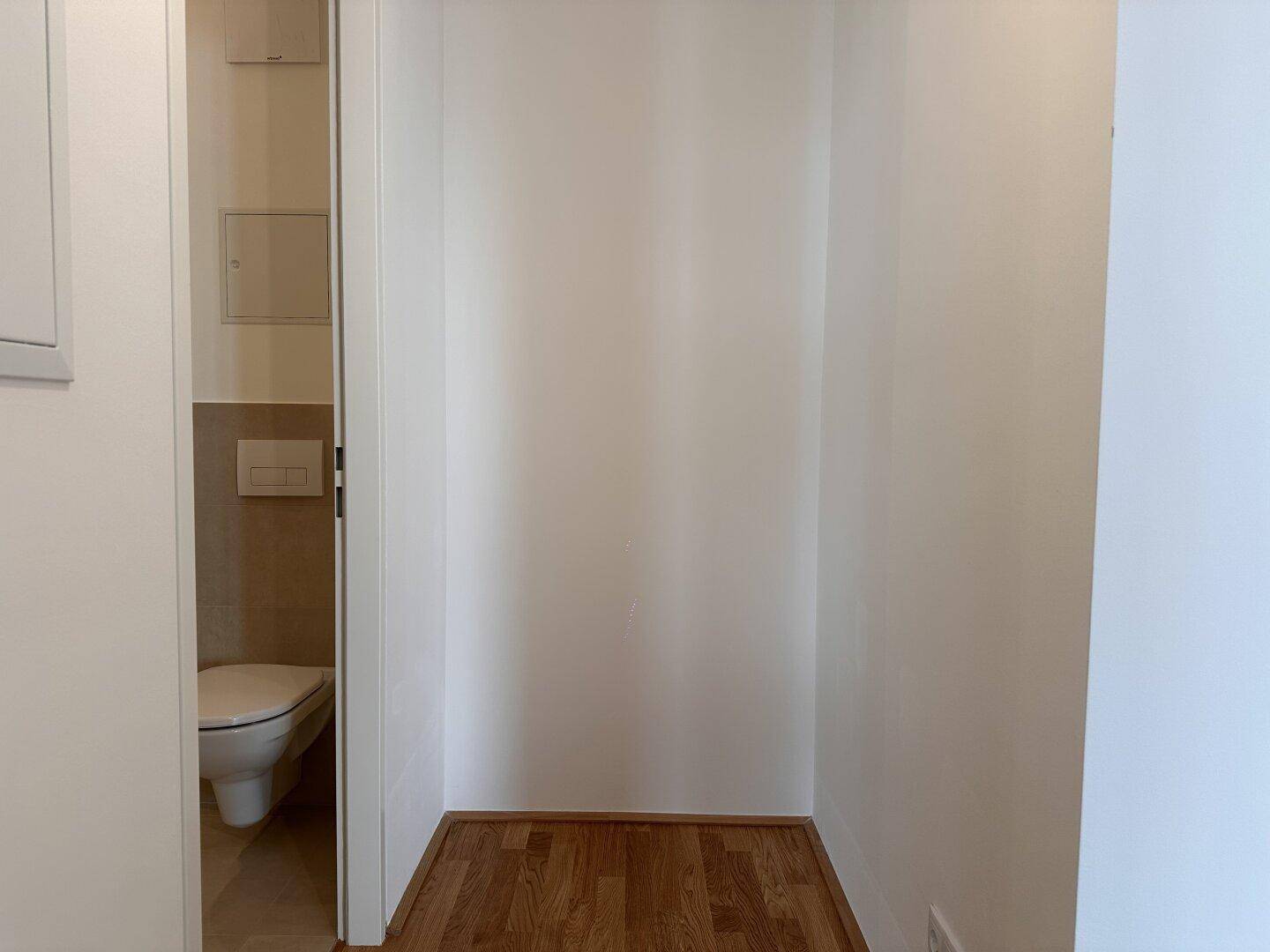 Kleines, helles WC mit Wand-WC und Fliesenboden, ideal für Gäste.