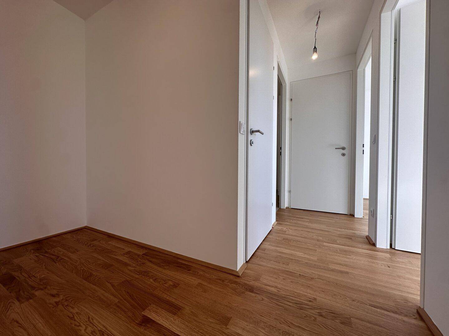 Heller Flur mit mehreren Türen, die zu den einzelnen Räumen der Wohnung führen.