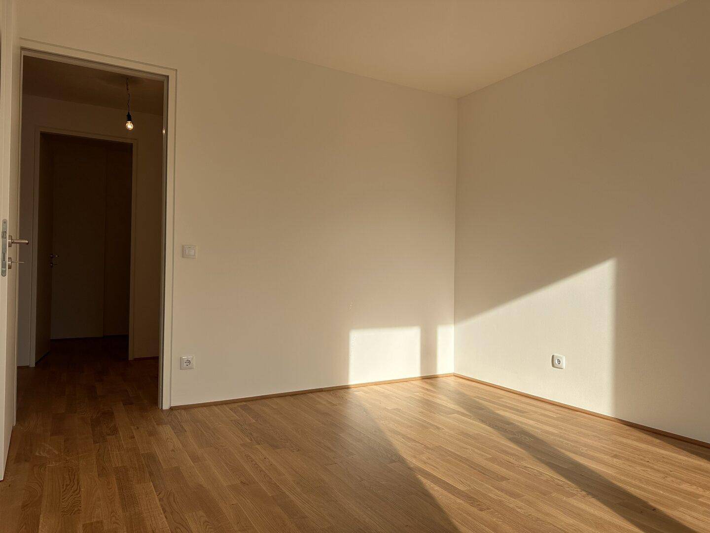 Gemütliches Zimmer mit Parkettboden und weiß gestrichenen Wänden, bereit zur individuellen Gestaltung.