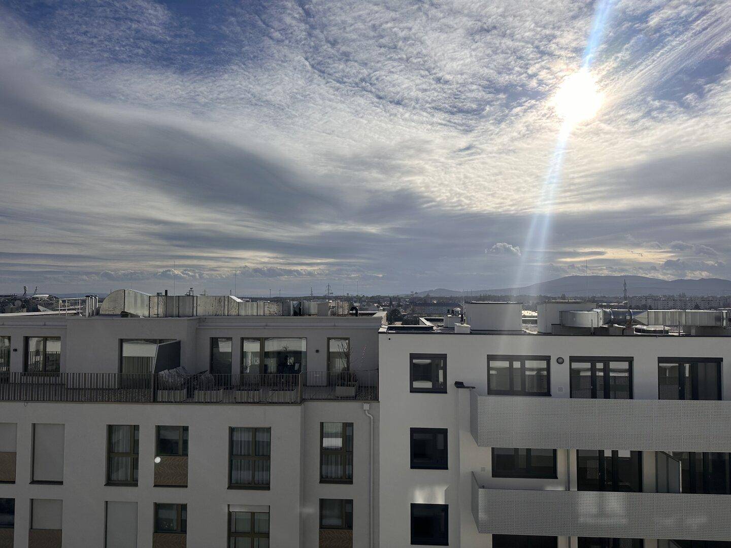 Panoramablick über die Stadt und die Dächer der Gebäude unter einem sonnigen Himmel.