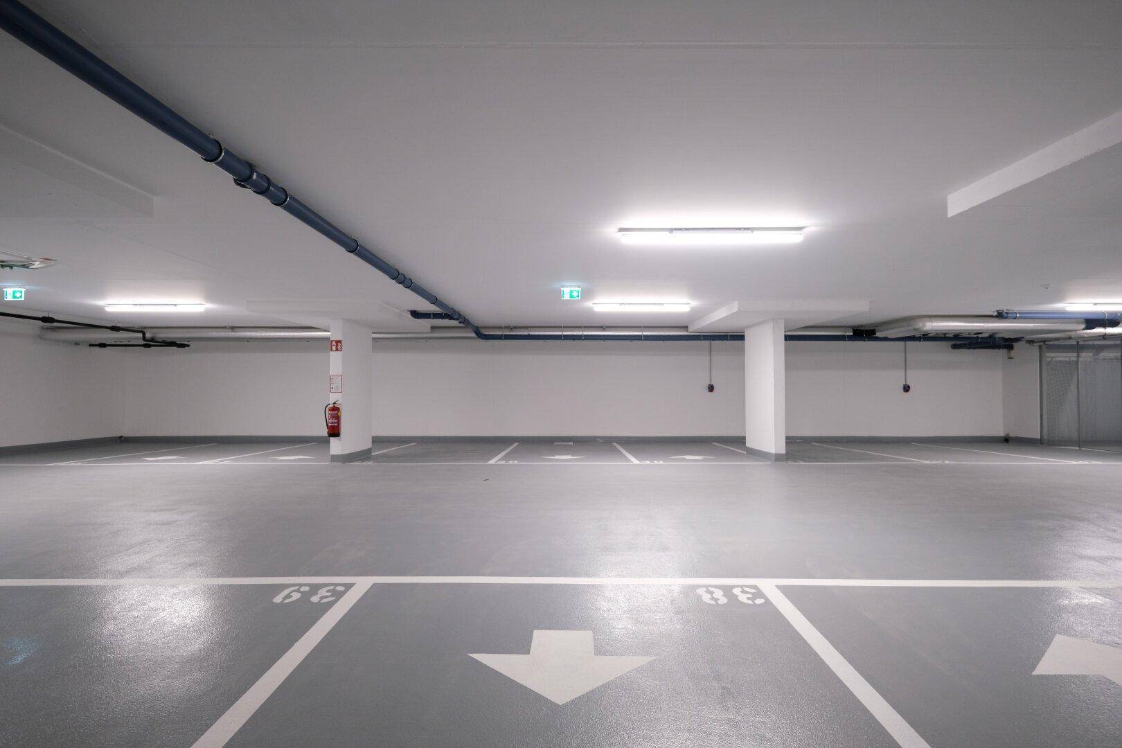 Geräumige Tiefgarage mit markierten Parkplätzen und guter Beleuchtung.