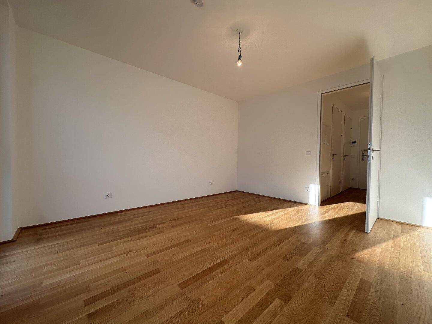 Geräumiges Zimmer mit hellem Parkettboden und weiß gestrichenen Wänden, ideal für individuelle Gestaltung.