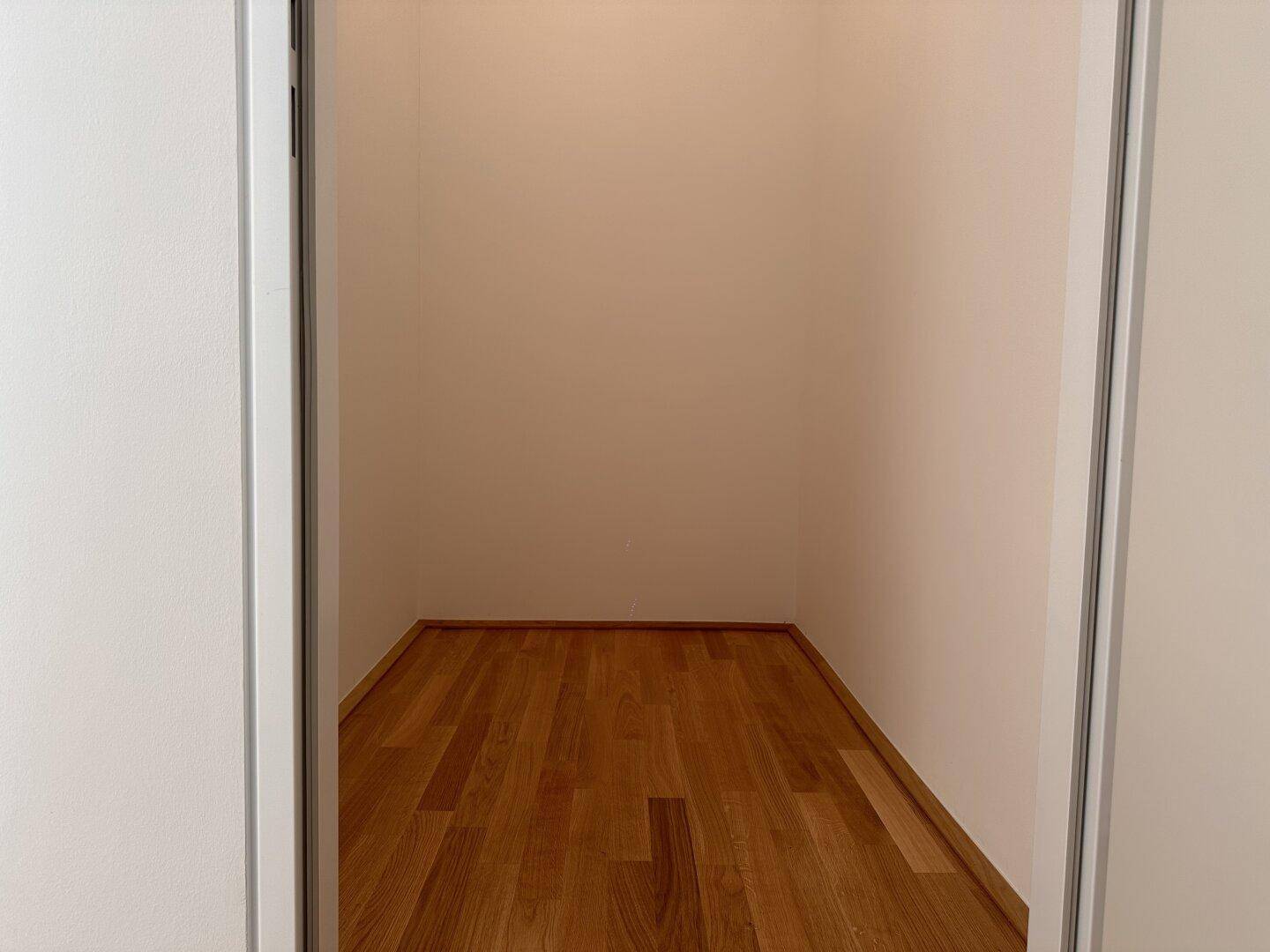 Leerer Abstellraum mit Holzboden, bereit zur Nutzung als praktischer Stauraum.