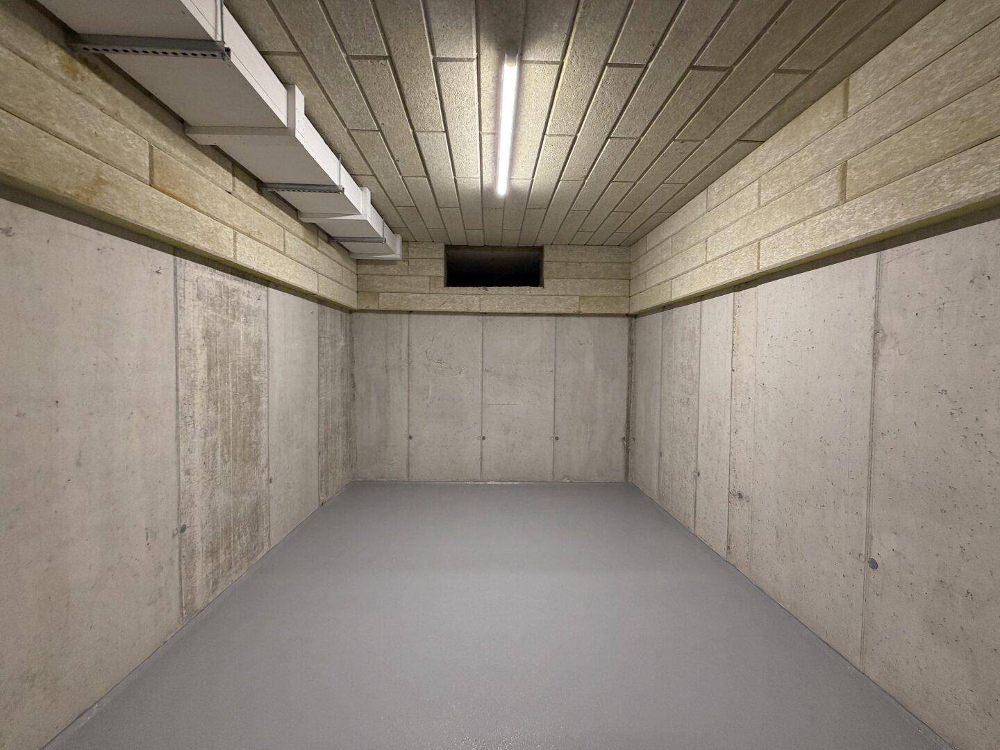 Kellerraum mit Betonwänden und Decke, ideal als Abstellraum nutzbar.