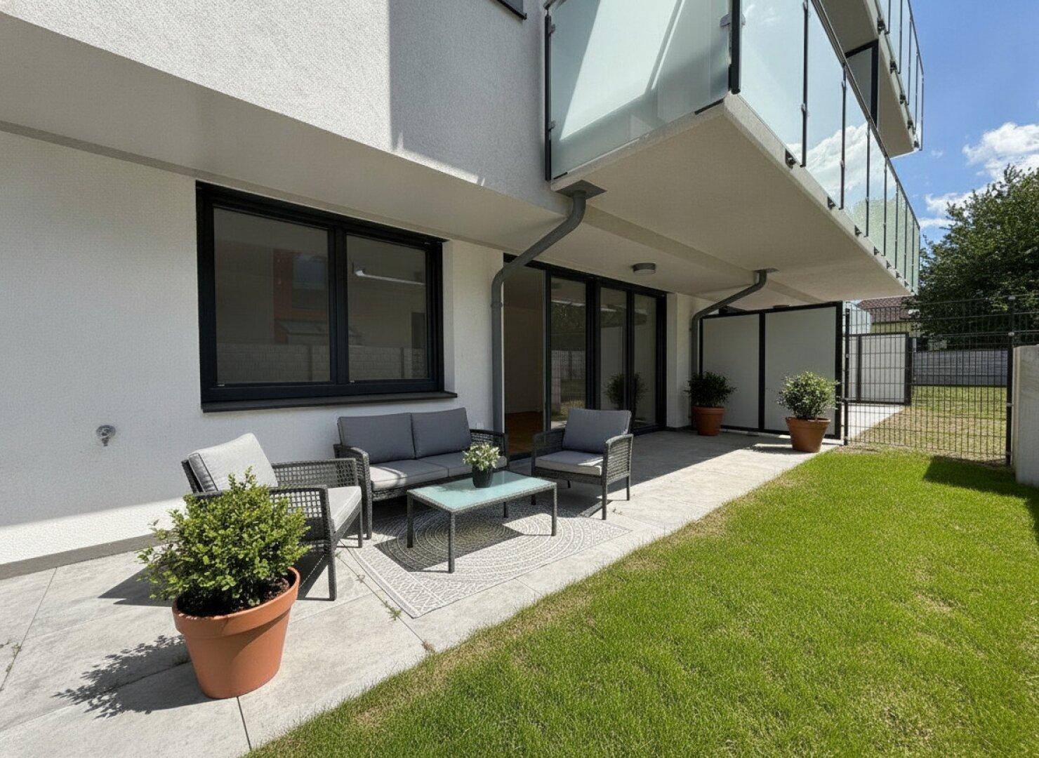 Gemütliche Terrasse mit modernen Gartenmöbeln und angrenzender Rasenfläche.