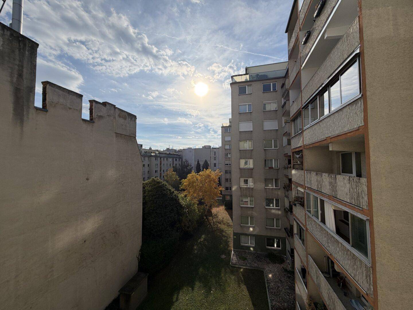 Sonniger Ausblick auf die umliegenden Wohngebäude und grüne Bäume an einem klaren Tag.